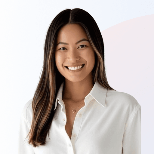 Smiling woman with long dark hair wearing a white button-up shirt against a light background.